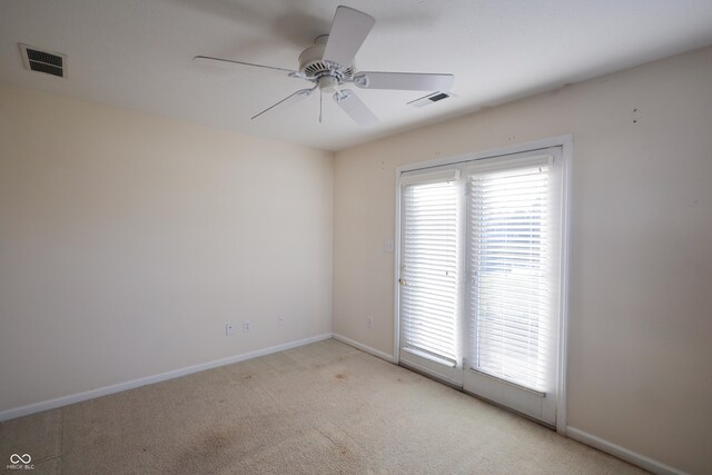 carpeted spare room featuring ceiling fan