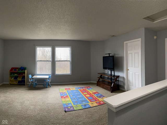 playroom with carpet flooring and a textured ceiling