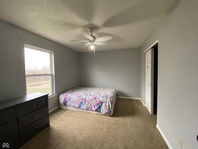 bedroom featuring carpet, a textured ceiling, a closet, and ceiling fan