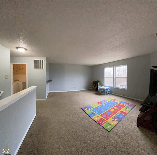 recreation room featuring a textured ceiling and carpet floors