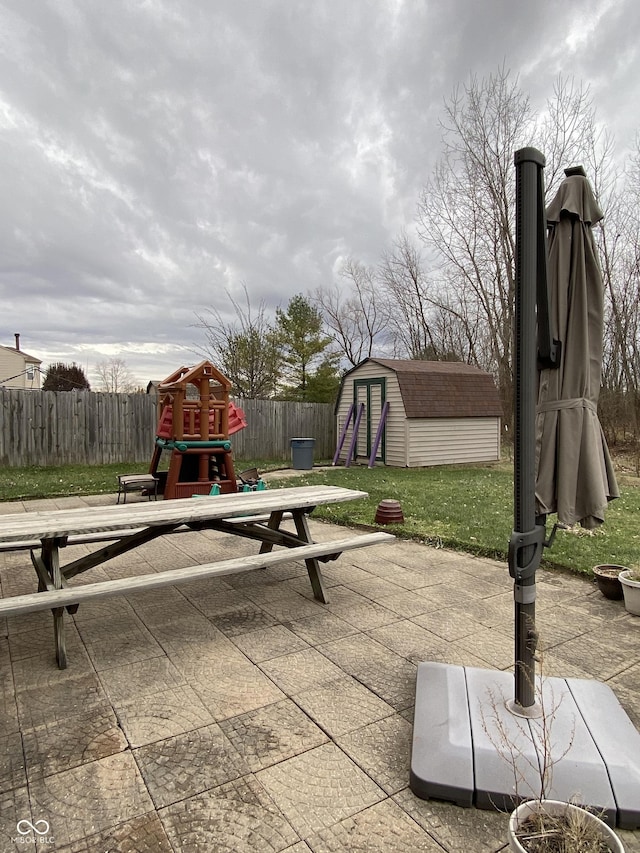 view of patio featuring a playground and a storage shed