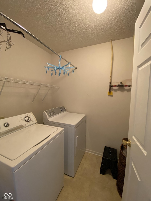 laundry area with washer and dryer and a textured ceiling