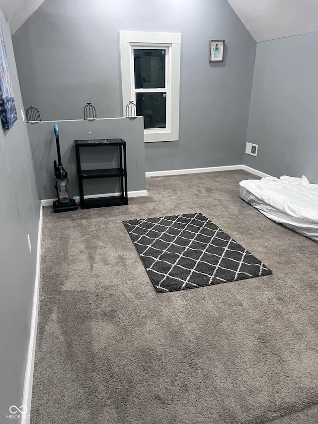 interior space featuring carpet flooring and vaulted ceiling