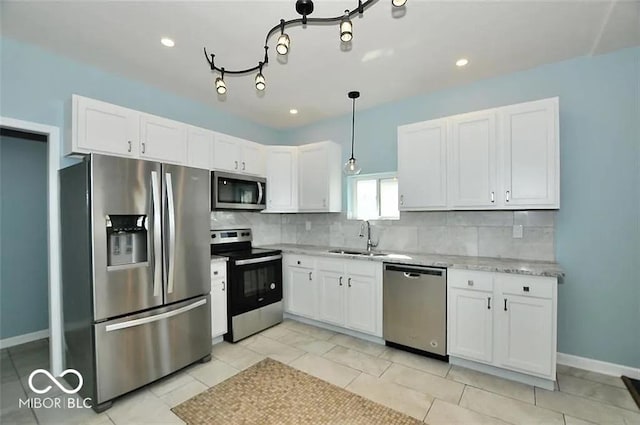 kitchen with white cabinetry, sink, hanging light fixtures, decorative backsplash, and appliances with stainless steel finishes