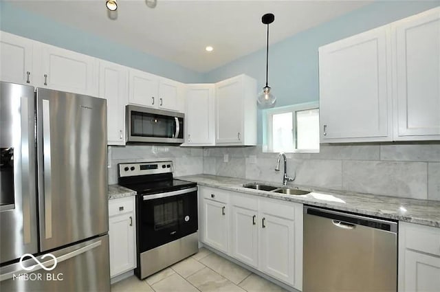 kitchen with decorative backsplash, stainless steel appliances, sink, pendant lighting, and white cabinetry