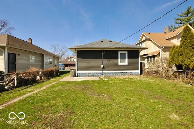 rear view of property featuring a lawn