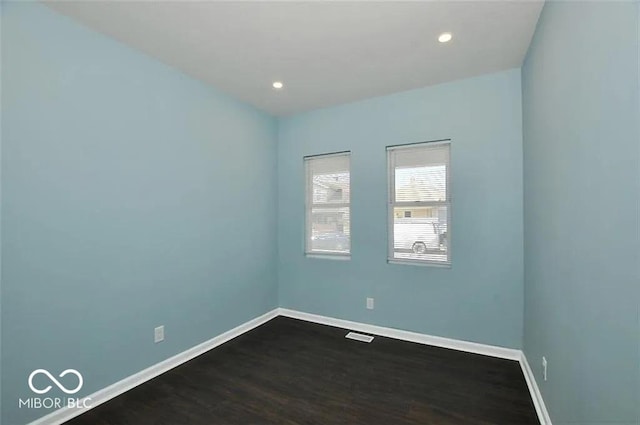 empty room with dark hardwood / wood-style flooring