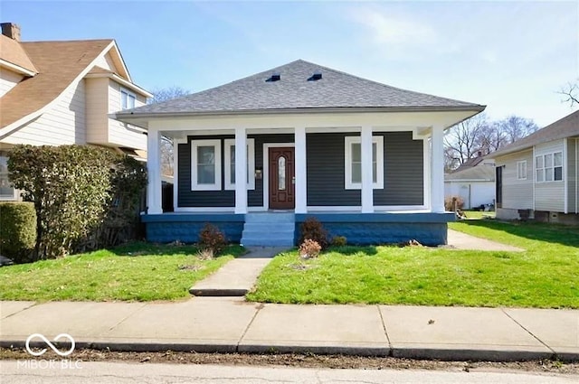 bungalow-style home with covered porch and a front yard