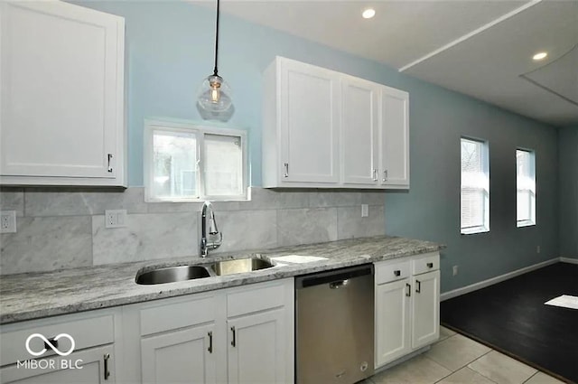 kitchen featuring white cabinetry, stainless steel dishwasher, hanging light fixtures, and light tile patterned flooring