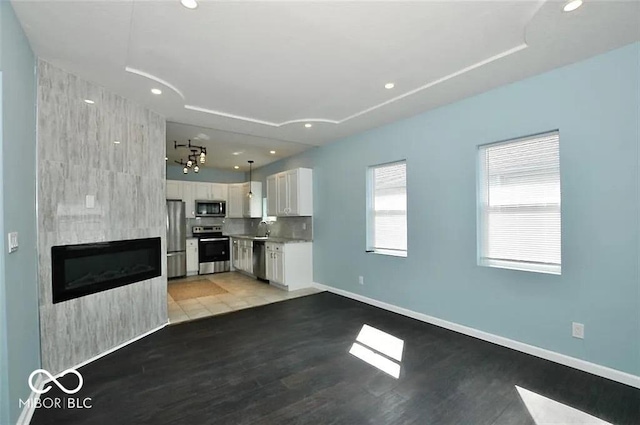 unfurnished living room with a fireplace, wood-type flooring, and sink