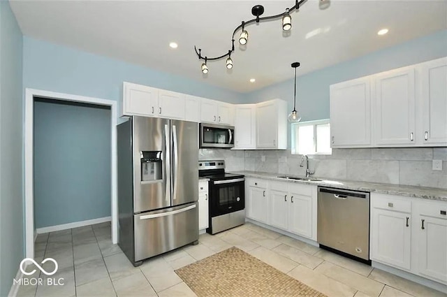 kitchen featuring appliances with stainless steel finishes, backsplash, sink, white cabinets, and hanging light fixtures