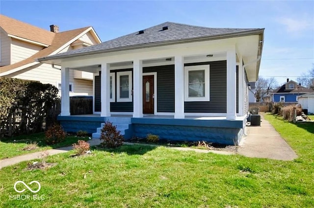 bungalow featuring cooling unit, a front lawn, and covered porch