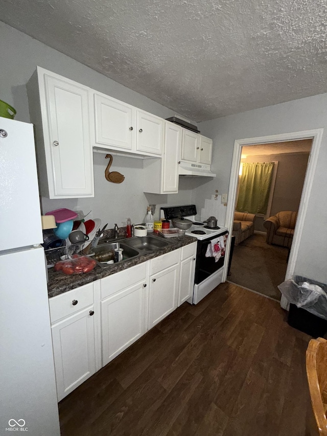 kitchen with white cabinets, a textured ceiling, white appliances, and dark wood-type flooring