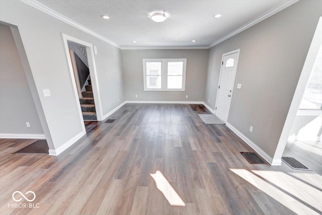 interior space with crown molding, wood finished floors, and baseboards