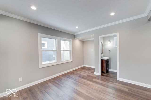 unfurnished living room with crown molding, baseboards, and wood finished floors