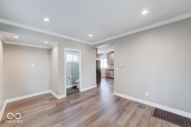 spare room featuring baseboards, visible vents, and wood finished floors