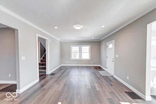 interior space with a textured ceiling, dark wood-type flooring, visible vents, baseboards, and stairs