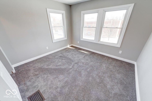 spare room featuring visible vents, baseboards, and carpet flooring