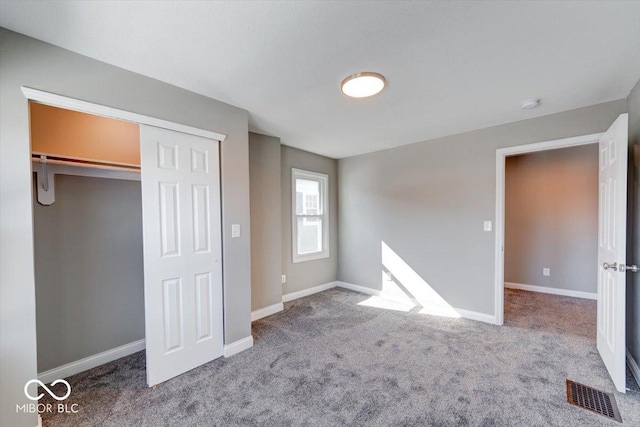 unfurnished bedroom featuring carpet, a closet, visible vents, and baseboards