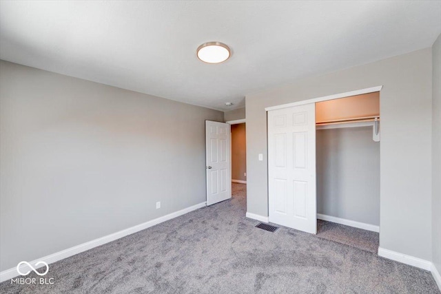 unfurnished bedroom featuring visible vents, a closet, baseboards, and carpet flooring