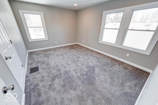 empty room with plenty of natural light, visible vents, and baseboards