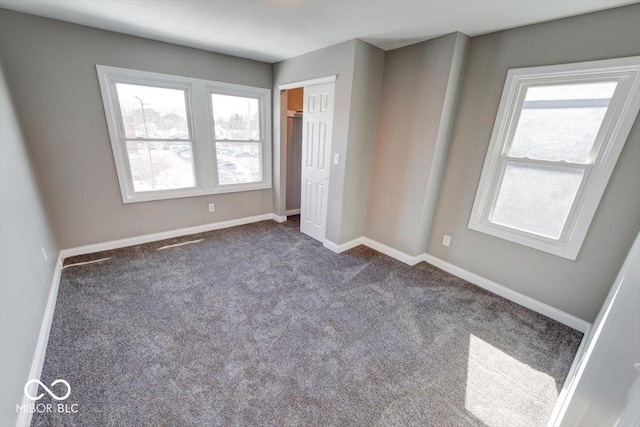 unfurnished bedroom with carpet floors, a closet, and baseboards