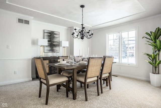 carpeted dining room featuring ornamental molding and a chandelier