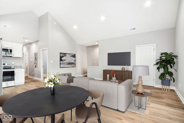 living room featuring light hardwood / wood-style floors and high vaulted ceiling