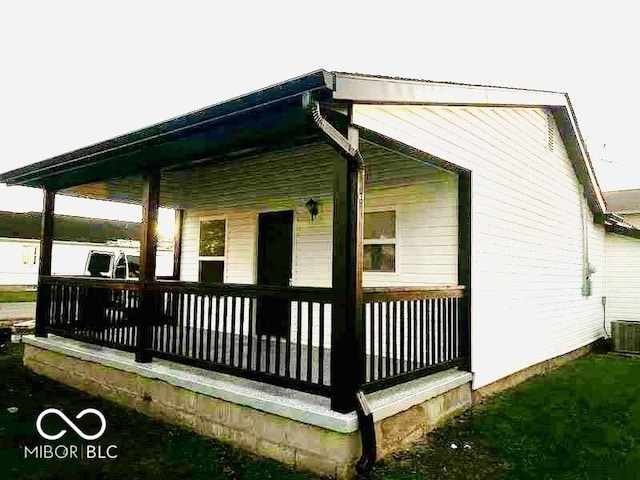 view of home's exterior with a porch and central AC