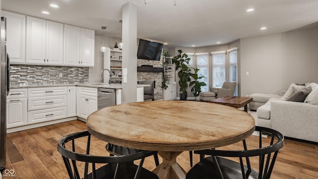 dining room with a fireplace, hardwood / wood-style flooring, and sink