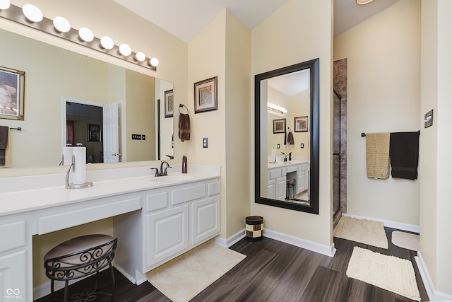 bathroom with a shower, hardwood / wood-style floors, and vanity