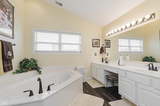 bathroom with vanity, a bath, lofted ceiling, and wood-type flooring