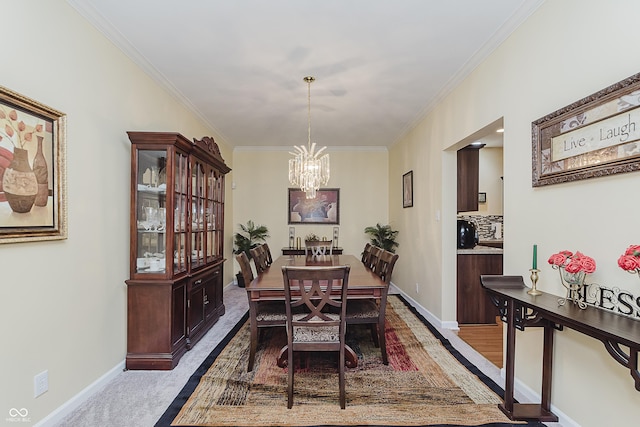 dining space with carpet flooring, crown molding, and a chandelier