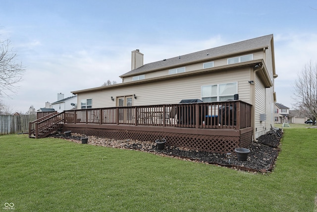 rear view of property featuring a deck and a lawn