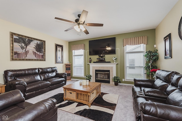 living room with a tile fireplace, light colored carpet, a wealth of natural light, and ceiling fan