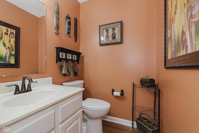 bathroom with hardwood / wood-style floors, vanity, and toilet