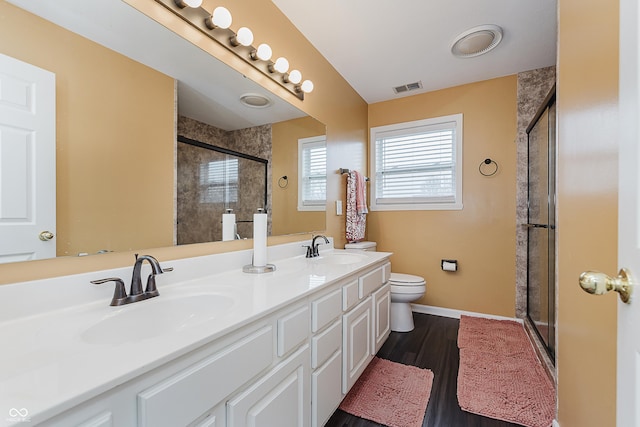 bathroom featuring toilet, an enclosed shower, wood-type flooring, and vanity