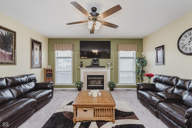 living room with light colored carpet, ceiling fan, and a tiled fireplace