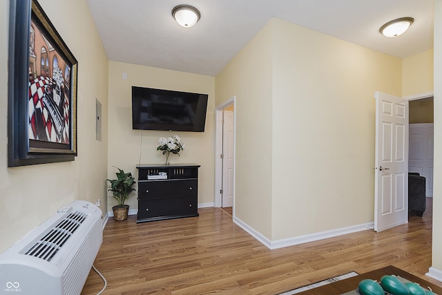 hallway featuring wood-type flooring and a wall unit AC