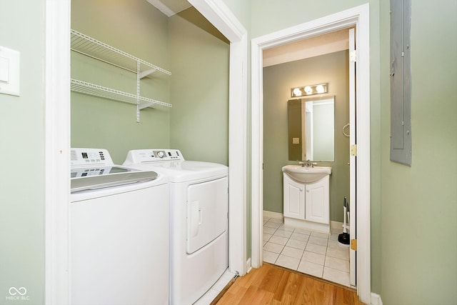 washroom with sink, washer and clothes dryer, and light wood-type flooring