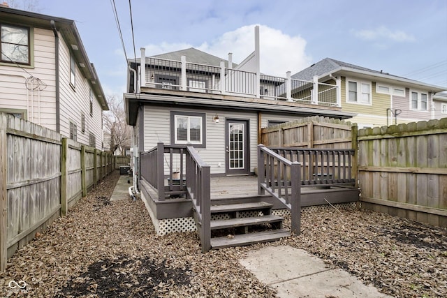 rear view of house with a balcony and a wooden deck