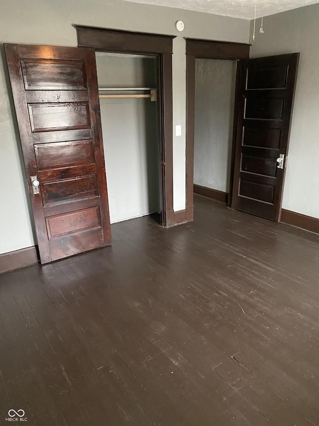 unfurnished bedroom featuring dark hardwood / wood-style floors and a closet