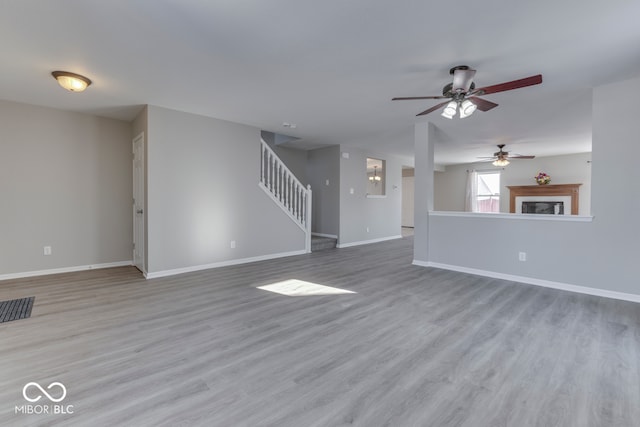 unfurnished living room featuring ceiling fan and light hardwood / wood-style flooring