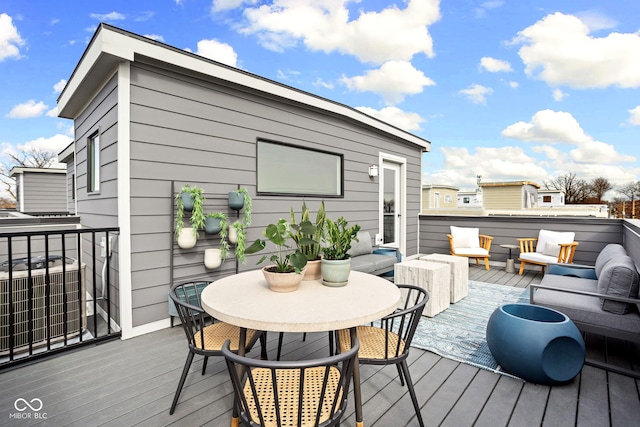 wooden terrace with an outdoor living space and central air condition unit