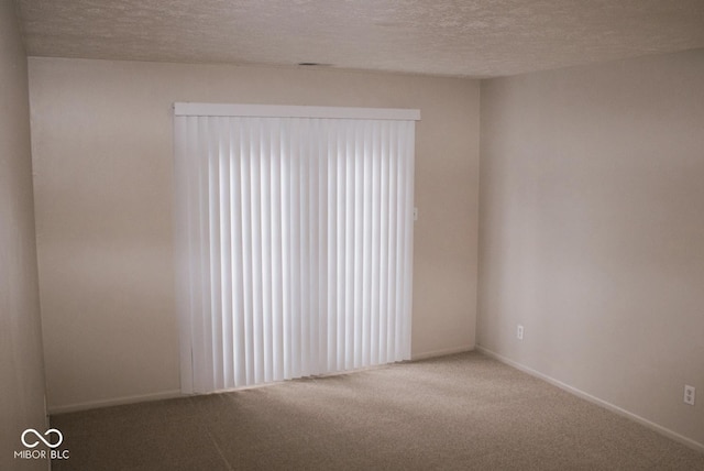 carpeted empty room featuring a textured ceiling