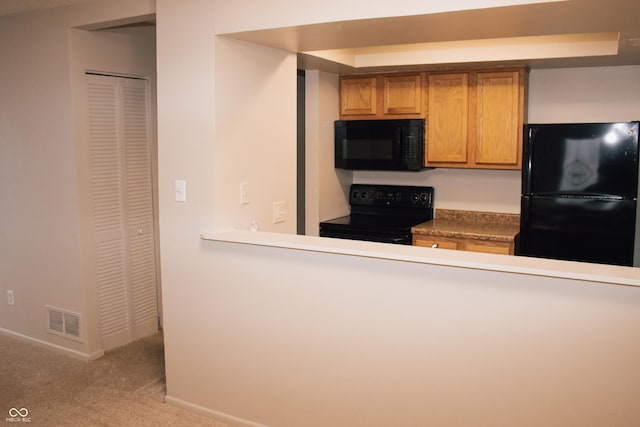 kitchen featuring black appliances and light carpet