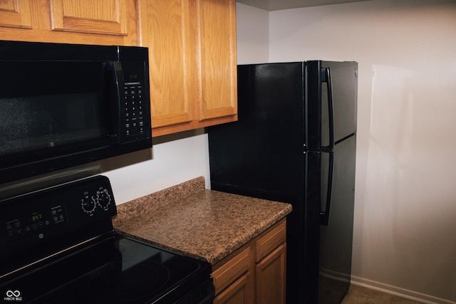 kitchen with dark stone counters and black appliances