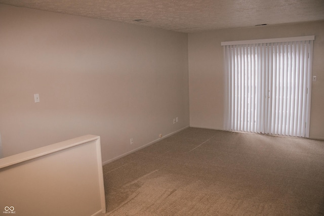 unfurnished room featuring carpet and a textured ceiling