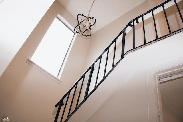 stairs featuring a notable chandelier