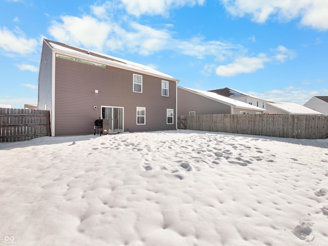 view of snow covered rear of property